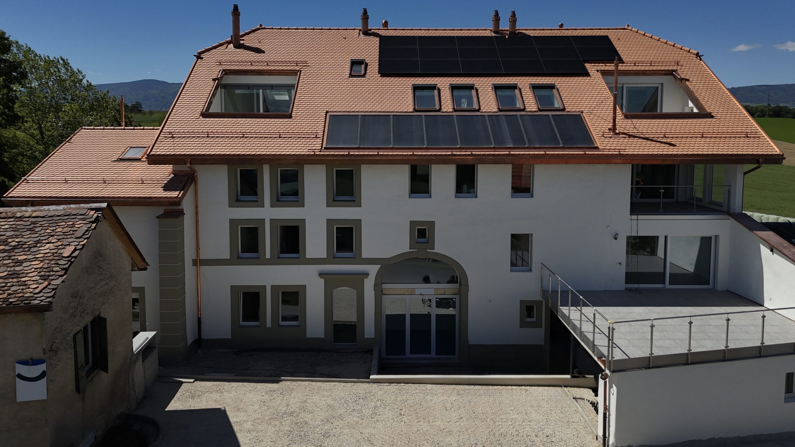 Façade rénovée du corps de ferme à Vullierens (VD), réhabilité en sept appartements par LEGATO EG tout en préservant le cachet patrimonial.